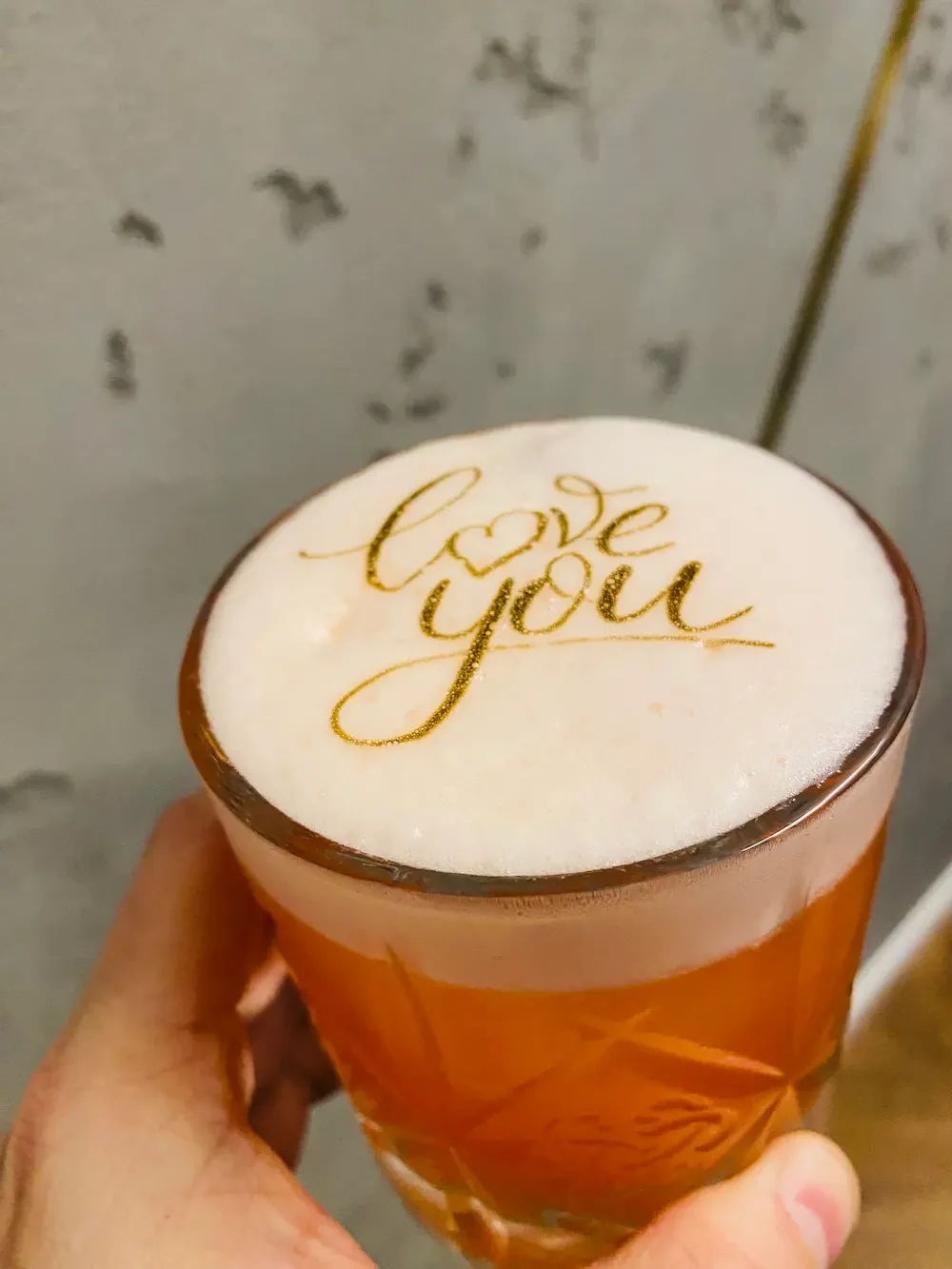 Koktajl z napisem love you wydrukowanym złotem na piance