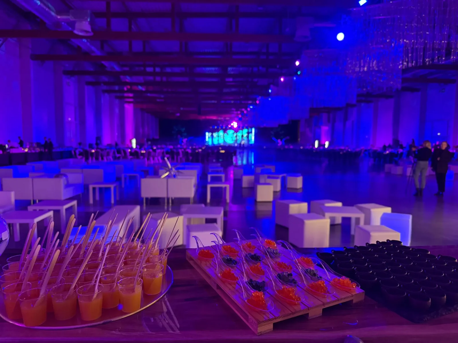Tace z shotami i probówkami na barze w hali eventowej w fioletowym świetle