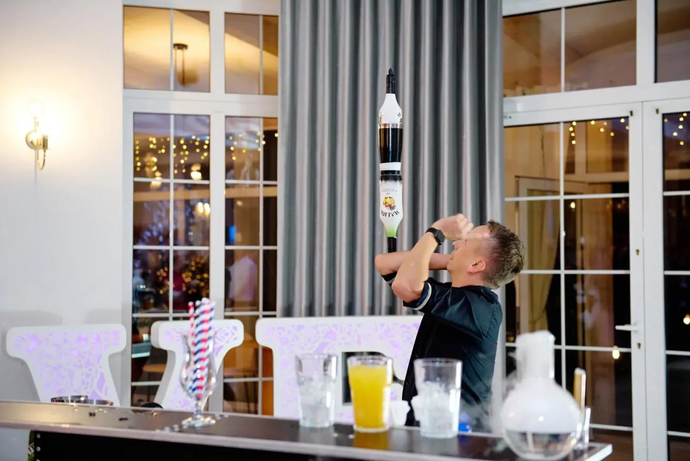 Barman balansujący butelkami podczas pokazu barmańskiego
