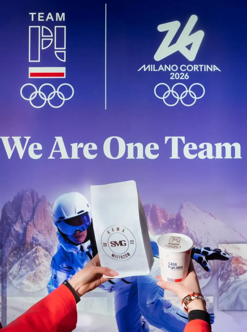 Kubek Casa Polonia i paczka kawy SMG przed grafiką Team PL na igrzyska Milano Cortina 2026