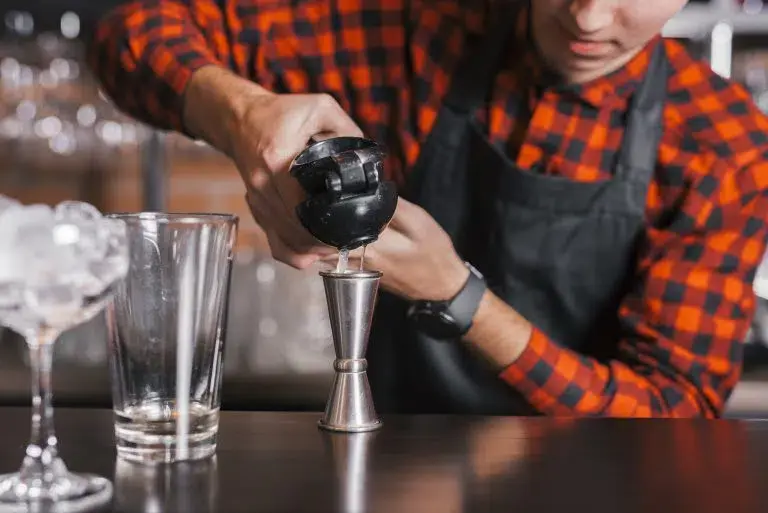 Barman przygotowuje koktajl przy barze