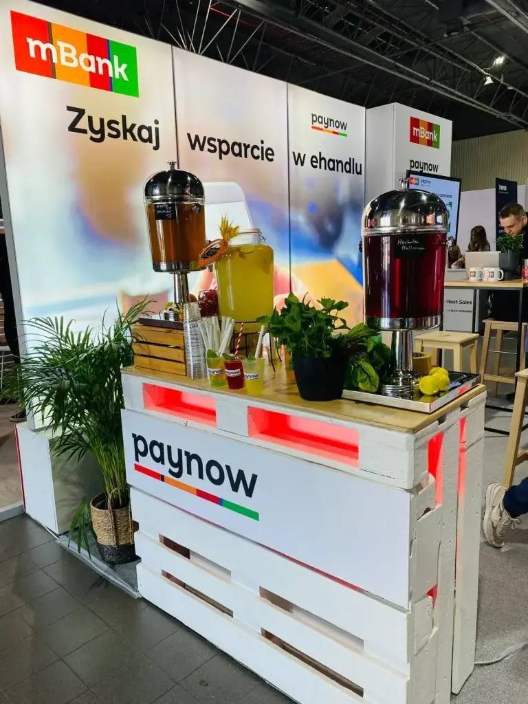 Stoisko mBank i paynow z dystrybutorami napojów, zielenią i hasłem 'Zyskaj wsparcie w ehandlu' w tle.